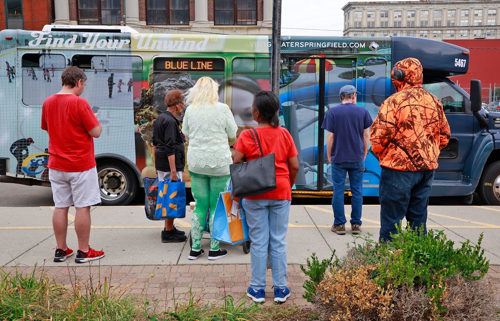 A group of people wait for the SCAT bus to arrive at the transit hub in downtown Springfield Thursday, August 15, 2024. BILL LACKEY/STAFF