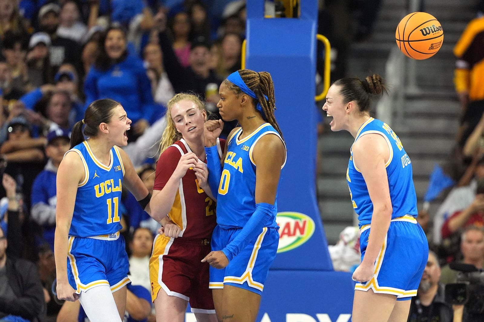 UCLA forward Angela Dugalic, right, celebrates along with guard Gabriela Jaquez, left, and forward Janiah Barker, second from right, after scoring while Southern California guard Avery Howell tries to through during the first half of an NCAA college basketball game Saturday, March 1, 2025, in Los Angeles. (AP Photo/Mark J. Terrill)