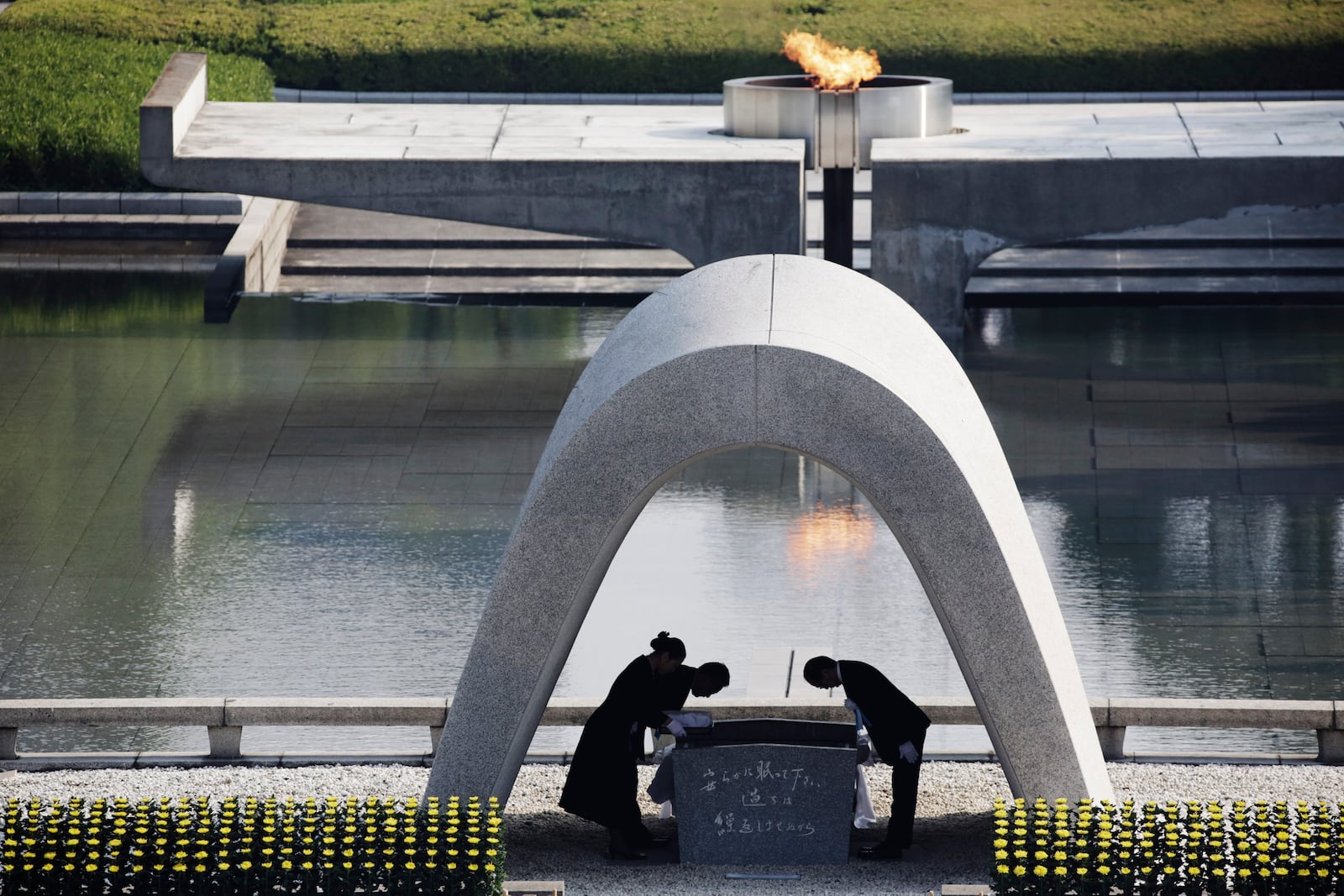 FILE - Kazumi Matsui, right, mayor of Hiroshima bows, at Hiroshima Memorial Cenotaph, at the Hiroshima Peace Memorial Park in Hiroshima, western Japan, Aug. 6, 2015. The Nobel Peace Prize has been awarded to Nihon Hidankyo, a Japanese organization of survivors of the U.S. atomic bombings of Hiroshima and Nagasaki, for its activism against nuclear weapons. (AP Photo/Eugene Hoshiko, File)