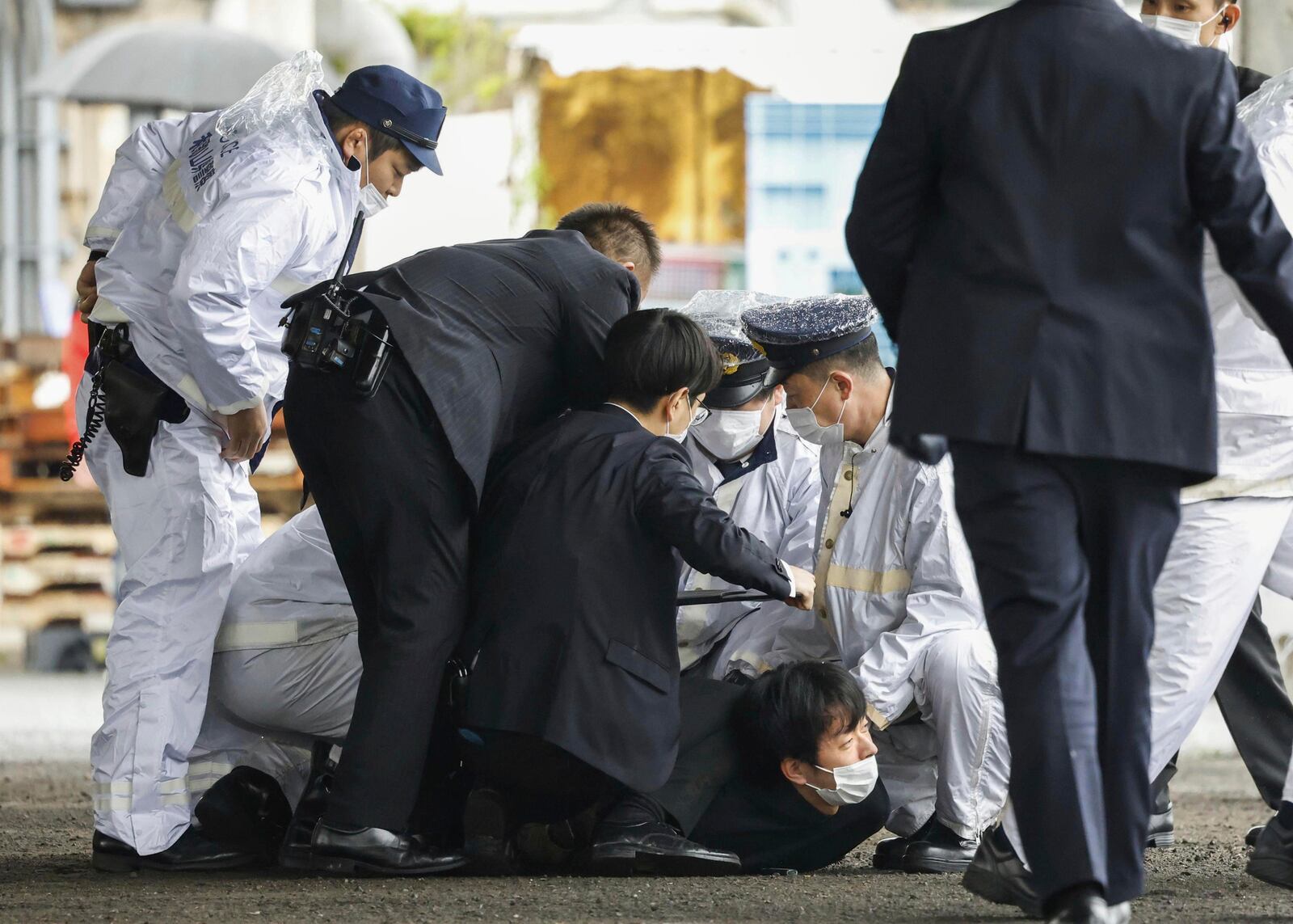 FILE - A suspect, center on the ground, is caught by police after he allegedly threw "the suspicious object," as Japanese Prime Minister Fumio Kishida visited Saikazaki port for an election campaign event in Wakayama, western Japan Saturday, April 15, 2023.(Kyodo News via AP, File)