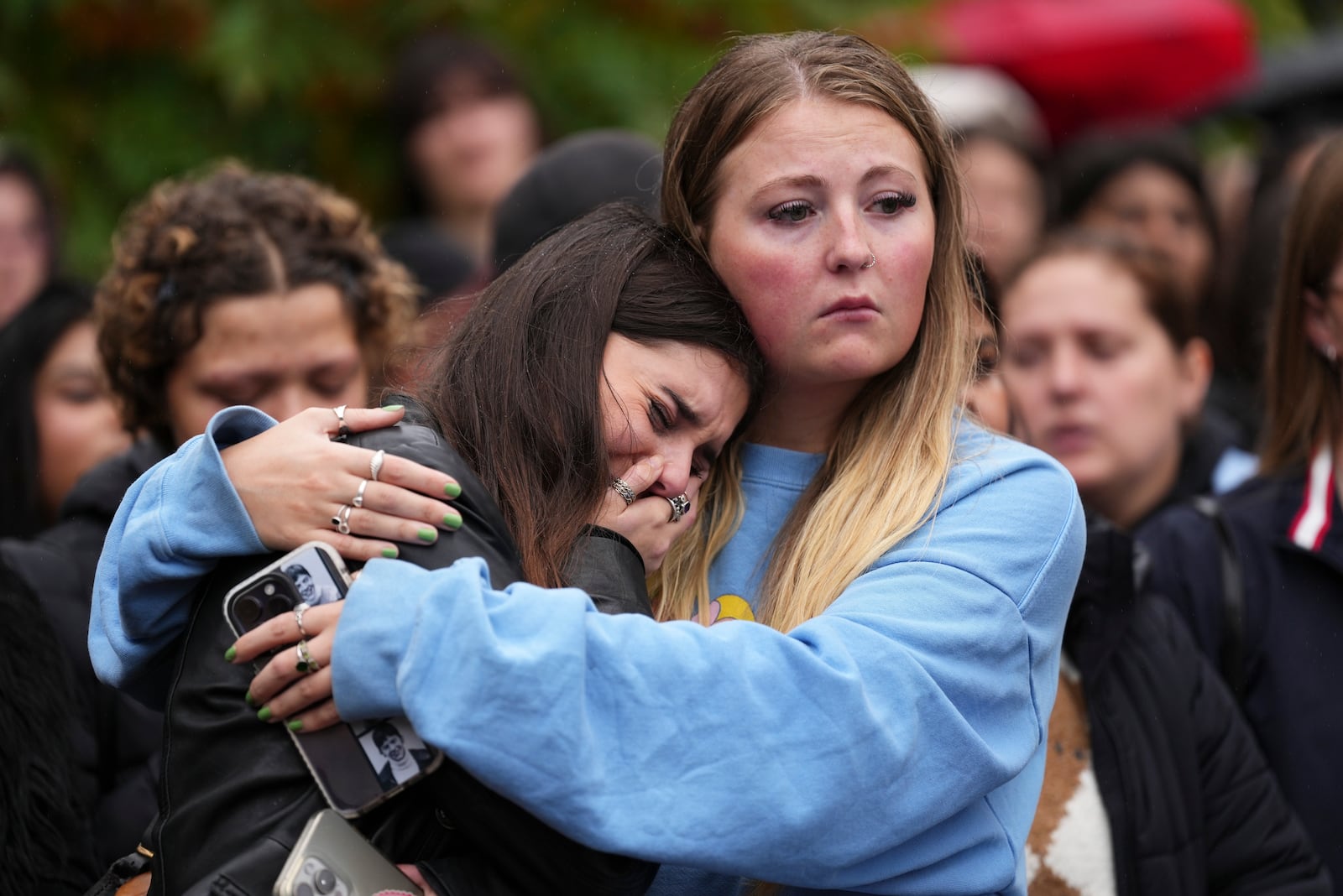 Fans react as they gather near the Peter Pan statue in Hyde Park, London to pay tribute to late British singer Liam Payne, former member of the British pop band One Direction, Sunday, Oct. 20, 2024. (Photo by Scott A Garfitt/Invision/AP)