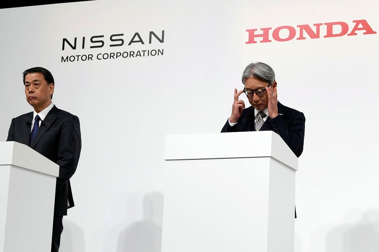 FILE - Nissan Chief Executive Makoto Uchida, left, and Honda Chief Executive Toshihiro Mibe, right, along with Takao Kato CEO of Mitsubishi Motors, not in photo, attend a joint news conference Monday, Dec. 23, 2024, in Tokyo, Japan. (AP Photo/Eugene Hoshiko, File)