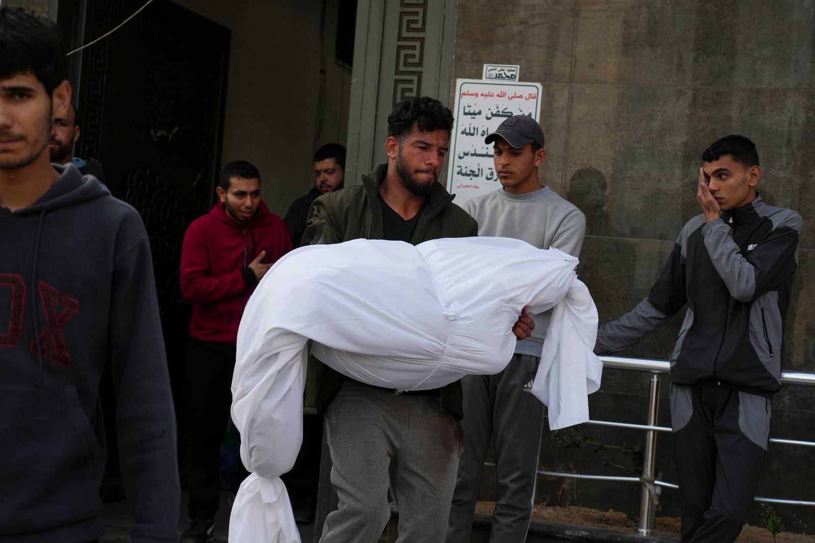 A body of a Palestinian killed in an Israeli army airstrikes is brought to Shifa Hospital in Gaza City, Tuesday, March 18, 2025. (AP Photo/Abdel Kareem Hana)