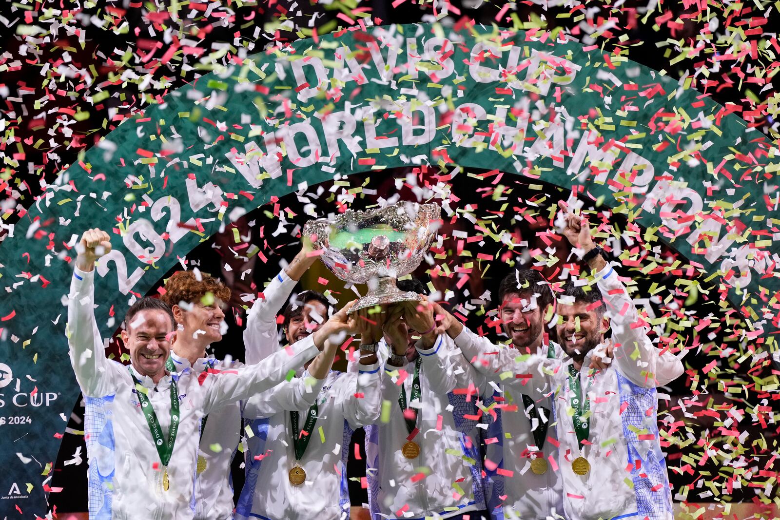 Italian tennis team members hold the Davis Cup trophy after the final between Netherlands and Italy at the Martin Carpena Sports Hall in Malaga, southern Spain, as Italy wins its second consecutive Davis Cup title, Sunday, Nov. 24, 2024. (AP Photo/Manu Fernandez)