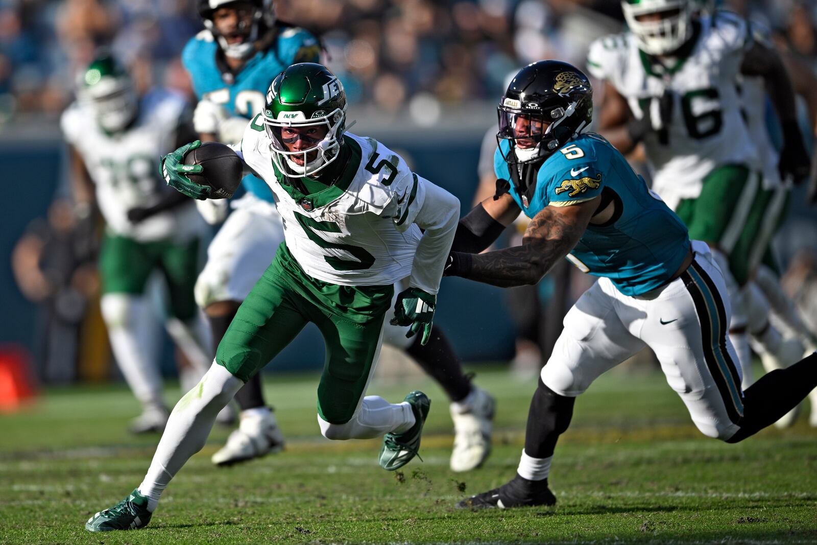 New York Jets wide receiver Garrett Wilson, left, gets away from Jacksonville Jaguars safety Andre Cisco after a catch during the second half of an NFL football game Sunday, Dec. 15, 2024, in Jacksonville, Fla. (AP Photo/Phelan M. Ebenhack)