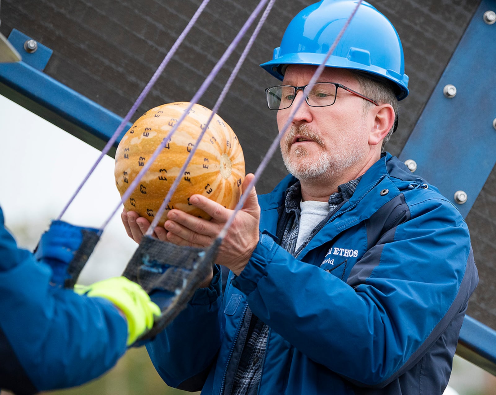 David Mollenhauer, Air Force Research Laboratory, loads a pumpkin into the Team ETHOS catapult in 2021 during the 16th annual Pumpkin Chuck at Wright-Patterson Air Force Base. The pumpkin was marked with “E3” all over its shell so officials would know which team made the shot when pieces of it were found a half-mile away. U.S. AIR FORCE PHOTO/R.J. ORIEZ