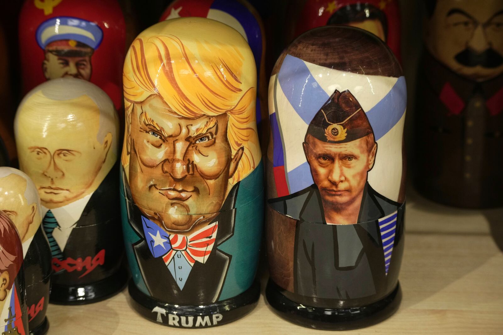 Traditional Russian wooden dolls called Matryoshka depicting Russian President Vladimir Putin, right, and US President Donald Trump are displayed for sale among others at a souvenir shop in St. Petersburg, Russia, Tuesday, March 18, 2025. (AP Photo/Dmitri Lovetsky)