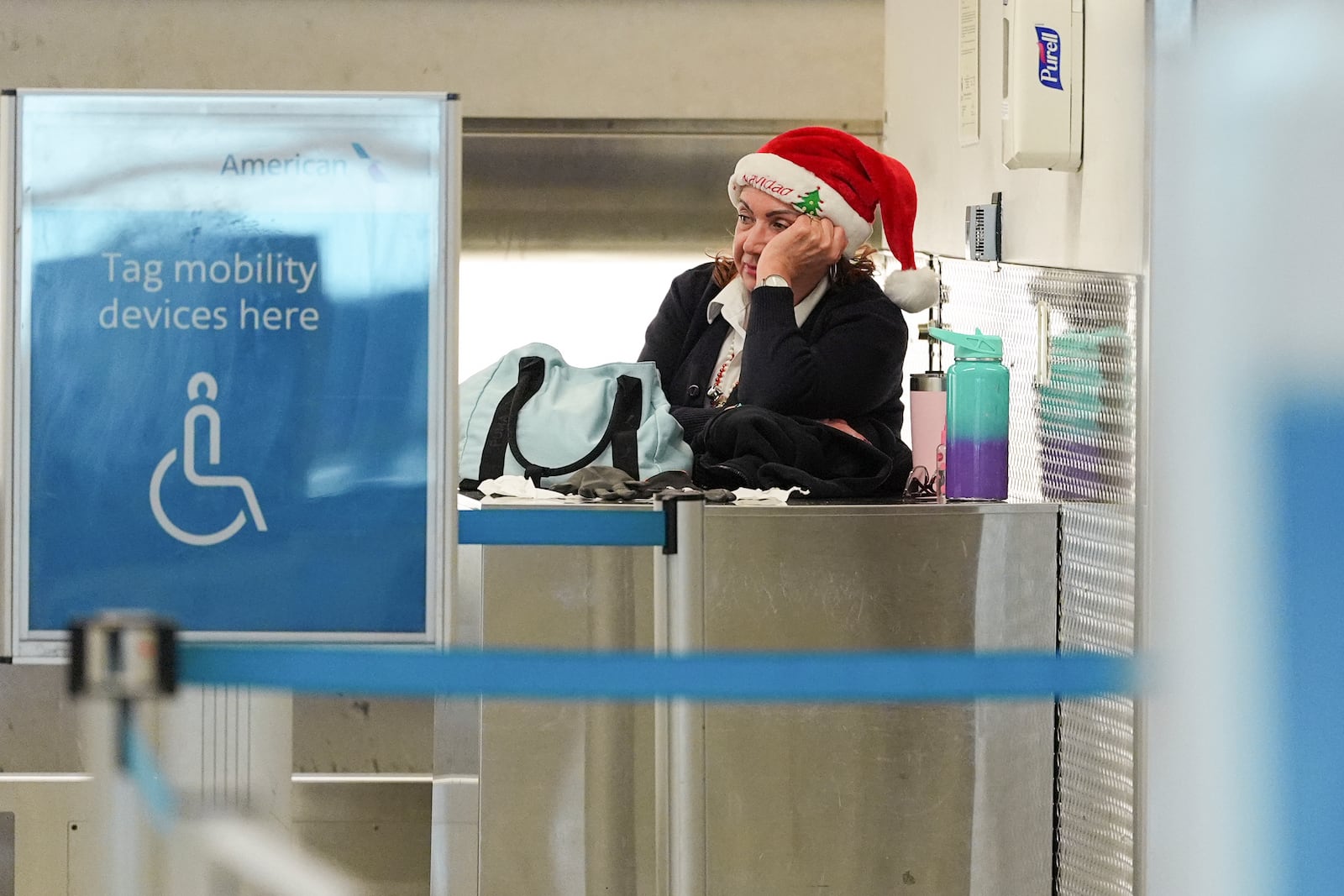 An American Airlines employee wearing a Santa Claus hat looks toward quiet check-in counters in the American terminal at Miami International Airport, on Christmas Eve, Tuesday, Dec. 24, 2024, in Miami. (AP Photo/Rebecca Blackwell)