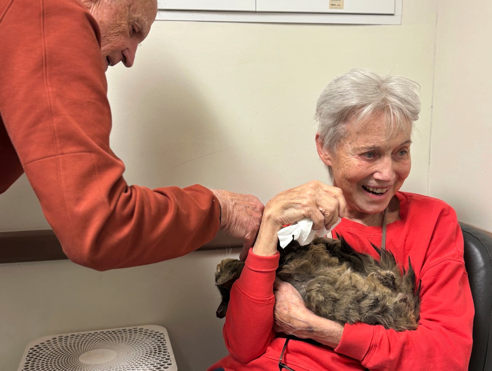 In this image provided by Carolyn Kiefer her mother, Katherine Kiefer, 82, is reunited with her cat Aggie at VCA Chatoak Animal Hospital after the Palisades Fire destroyed her home and the cat was missing, Saturday, March 8, 2025, in Los Angeles. (Carolyn Kiefer via AP)