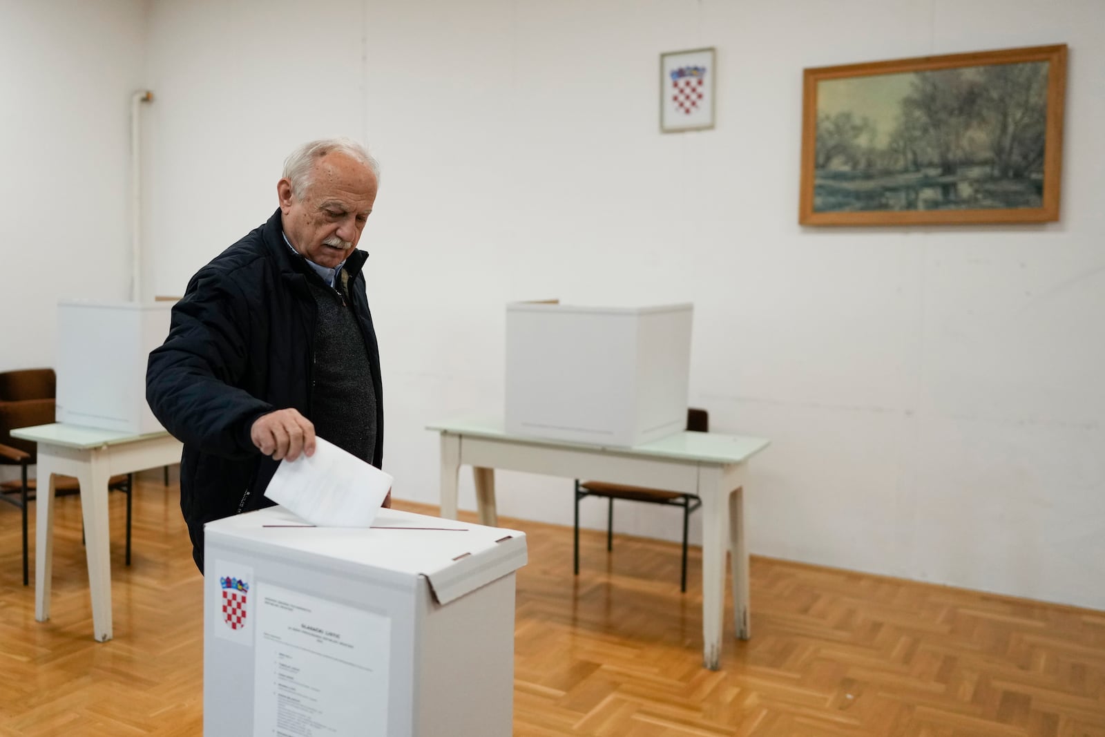 A man casts his ballot during a presidential election at a polling station in Zagreb, Croatia, Sunday, Dec. 29, 2024. (AP Photo/Darko Bandic)