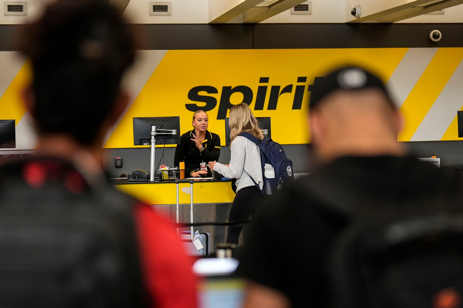 FILE - A traveler speaks with a Spirit Airlines agent at Hartsfield-Jackson Atlanta International Airport ahead of Memorial Day, on May 24, 2024, in Atlanta. (AP Photo/Mike Stewart, File)