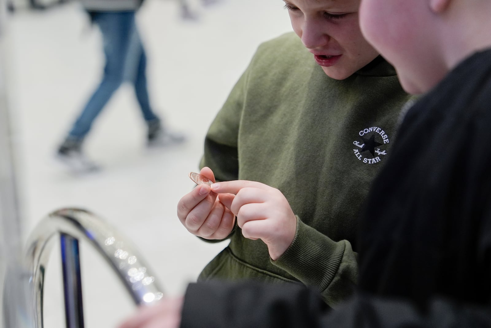 Brentley Joyce, 8, and Hunter Kimbel, 7, look at a souvenir penny from a penny press machine at the American Dream mall, Sunday, March 2, 2025, in East Rutherford, N.J. (AP Photo/Julia Demaree Nikhinson)