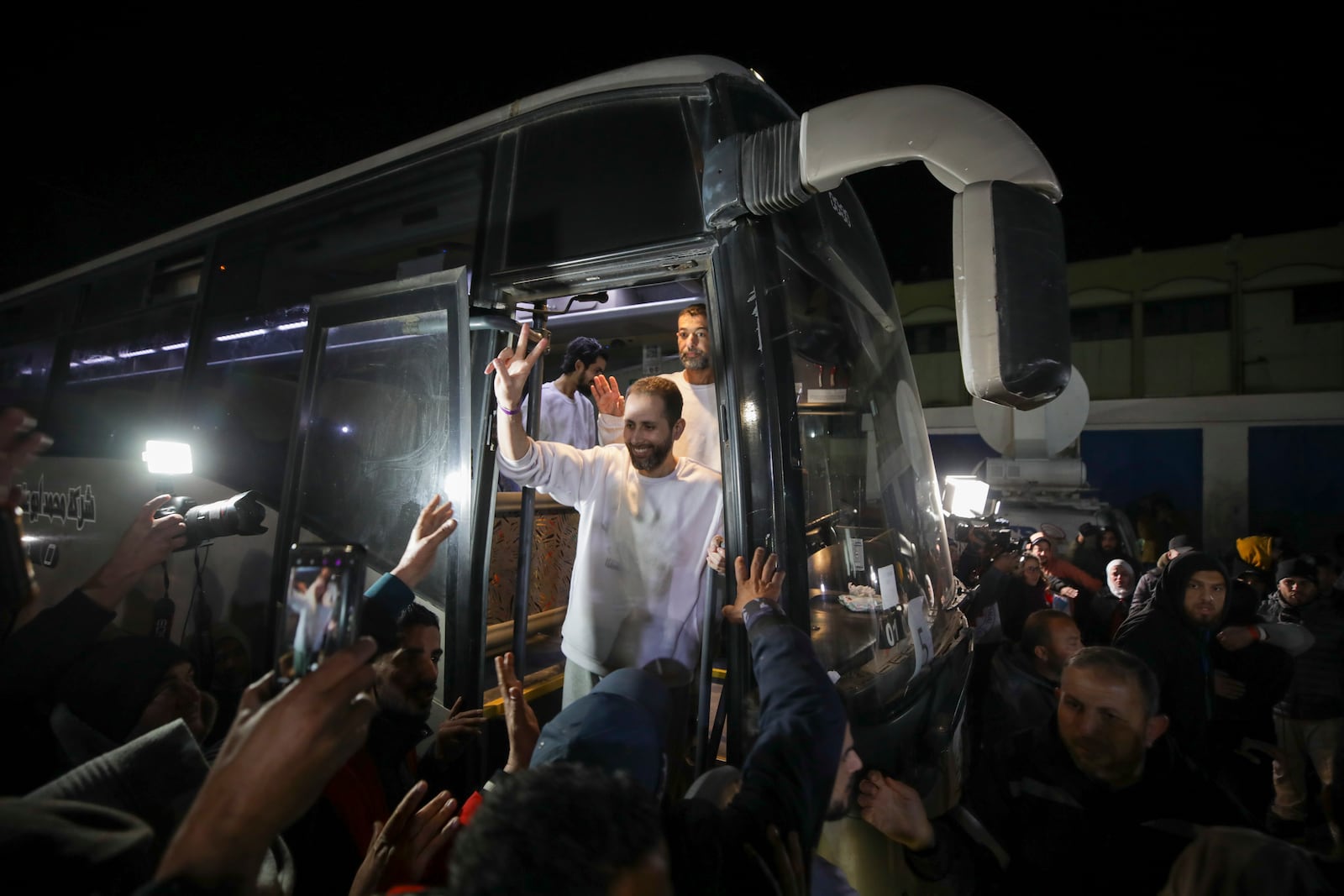 Freed Palestinian prisoners flash V-signs as they arrive in the Gaza Strip after being released from an Israeli prison following a ceasefire agreement between Hamas and Israel in Khan Younis, Gaza Strip, Thursday, Feb. 27, 2025. (AP Photo/Jehad Alshrafi)