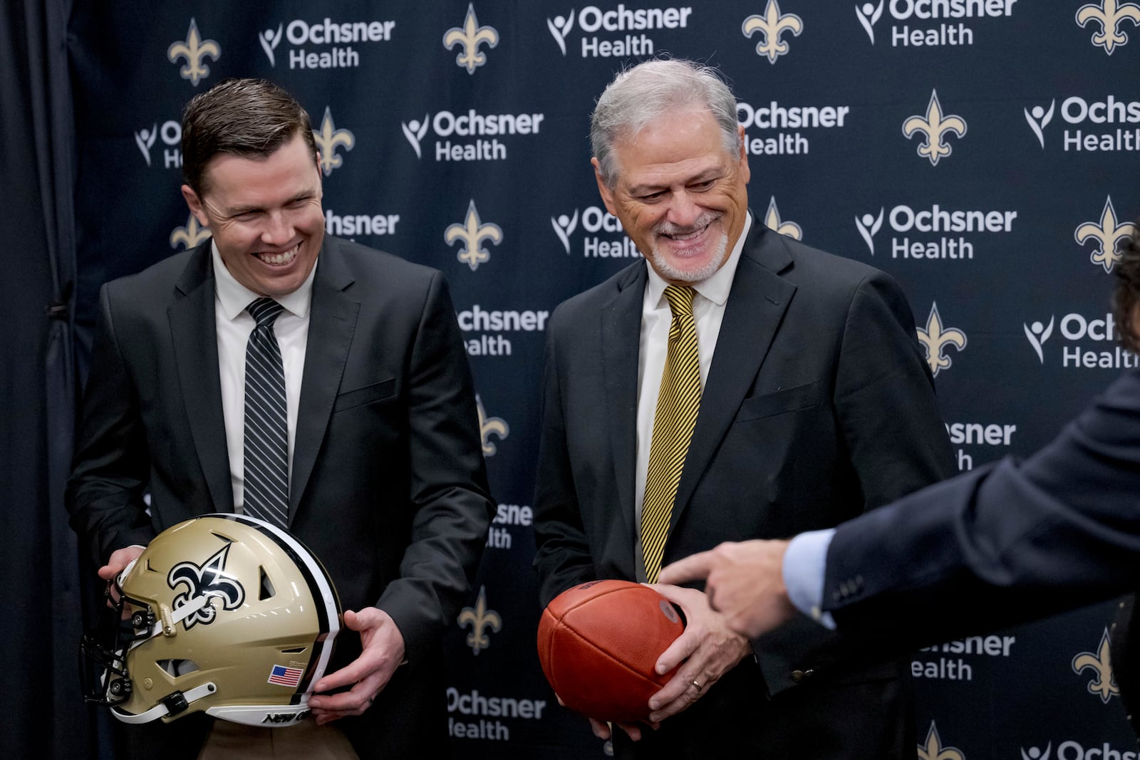 New Orlean Saints new coach Kellen Moore Kellen Moore, left, and Saints general manager Mickey Loomis, right, smile during an NFL football press conference in Metairie, La. Thursday, Feb. 13, 2025. (AP Photo/Matthew Hinton)