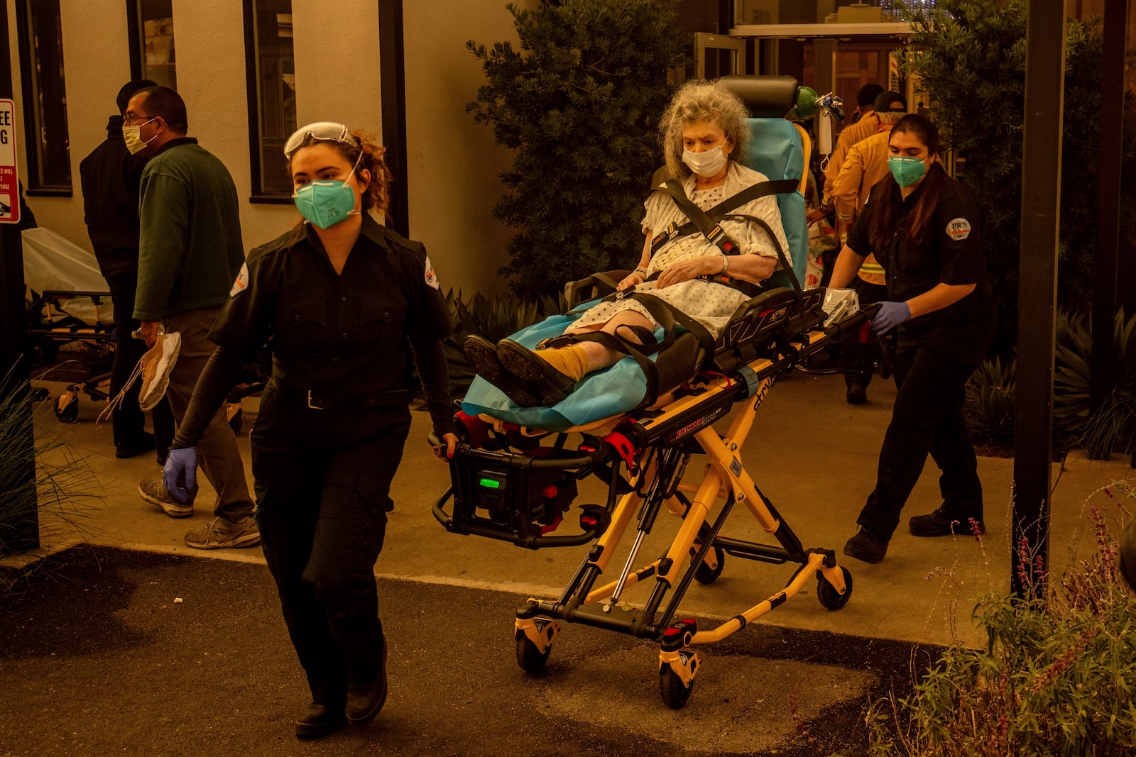 A resident is evacuated from a senior living facility as the Eaton Fire approaches Wednesday, Jan. 8, 2025, in Altadena, Calif. (AP Photo/Ethan Swope)