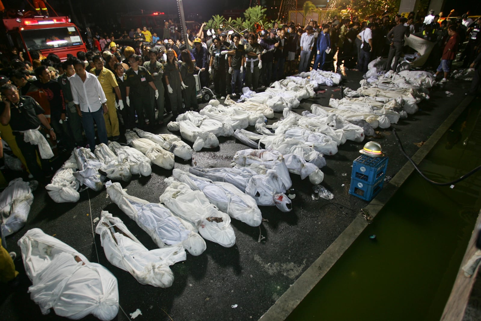 FILE - Fire and Rescue officials collect victims Thursday, Jan. 1, 2009, following a night club fire in Bangkok, Thailand. At least fifty people were killed when fire broke out during New Year's Eve celebrations at a popular Bangkok night club. (AP Photo/Sakchai Lalit, File)