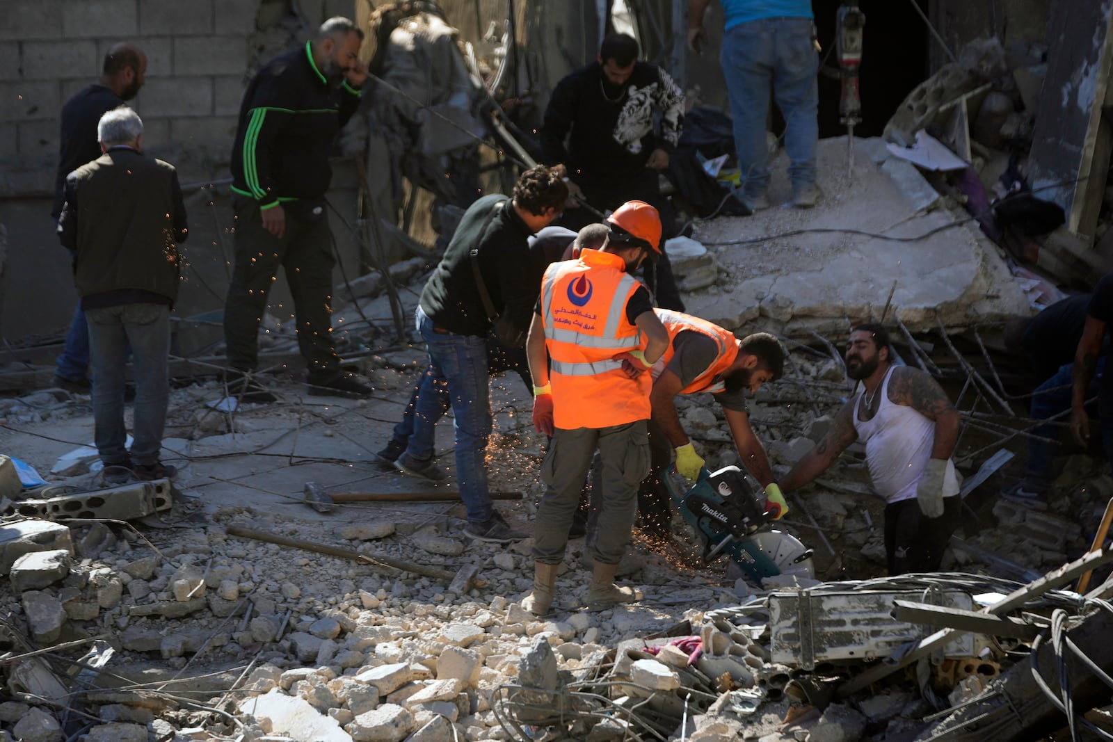 Rescue workers search for victims at the site of Israeli airstrikes that destroyed buildings facing the city's main government hospital in a densely-populated neighborhood, in southern Beirut, Lebanon, Tuesday, Oct. 22, 2024. (AP Photo/Hussein Malla)