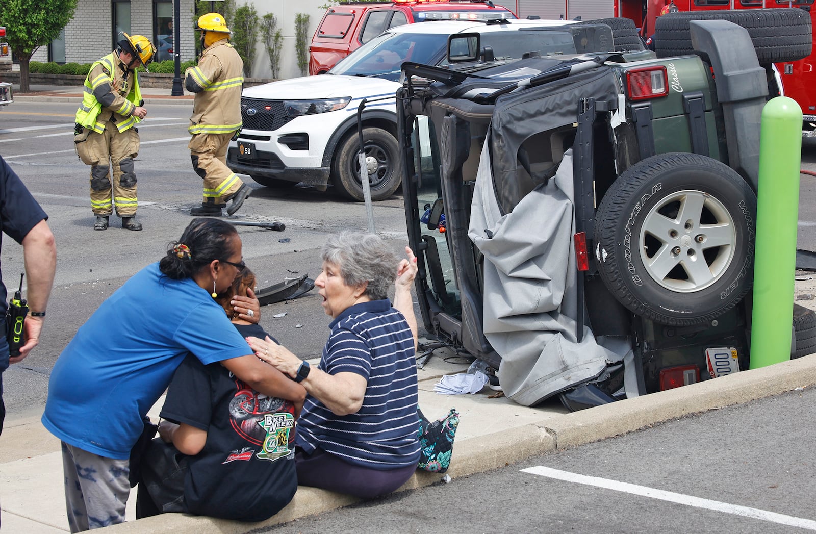 A mother hugs her son after he was involved in a two vehicle accident at the intersection of North Street and Fountain Avenue Monday, April 29, 2024. The two people in the jeep in the background had to be rescued from their overturned vehicle. They were transported to the hospital with non-life threatening injuries. The accident closed the intersection for a half hour while it was cleaned up. BILL LACKEY/STAFF