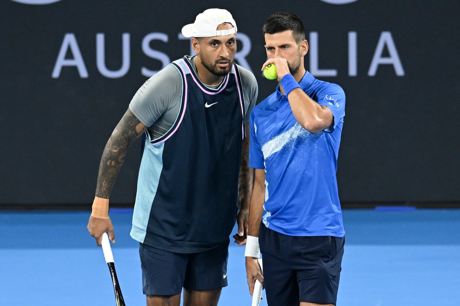 Australia's Nick Kyrgios, left, talks with Serbia's Novak Djokovic during their doubles match against Alexander Erler of Austria and Andreas Mies of Germany in the Brisbane International, at the Queensland Tennis Centre in Brisbane, Australia, Monday, Dec. 30, 2024. (Darren England/AAP Image via AP)