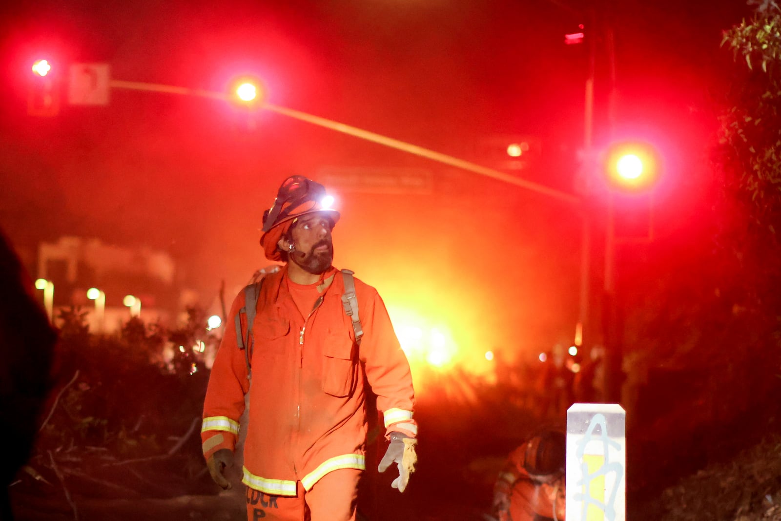 FILE - A California Department of Corrections hand crew works containment lines ahead of the Palisades Fire, Jan. 14, 2025, in Santa Monica, Calif. (AP Photo/Ethan Swope, File)