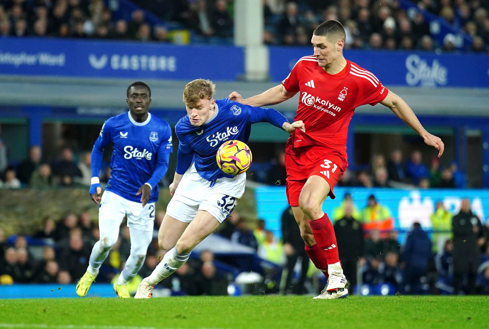 Everton's Jarrad Branthwaite, centre, and Nottingham Forest's Nikola Milenkovic battle for the ball during the English Premier League soccer match between Everton and Nottingham Forest at Goodison Park, Liverpool, England, Sunday, Dec. 29, 2024. (Peter Byrne/PA via AP)