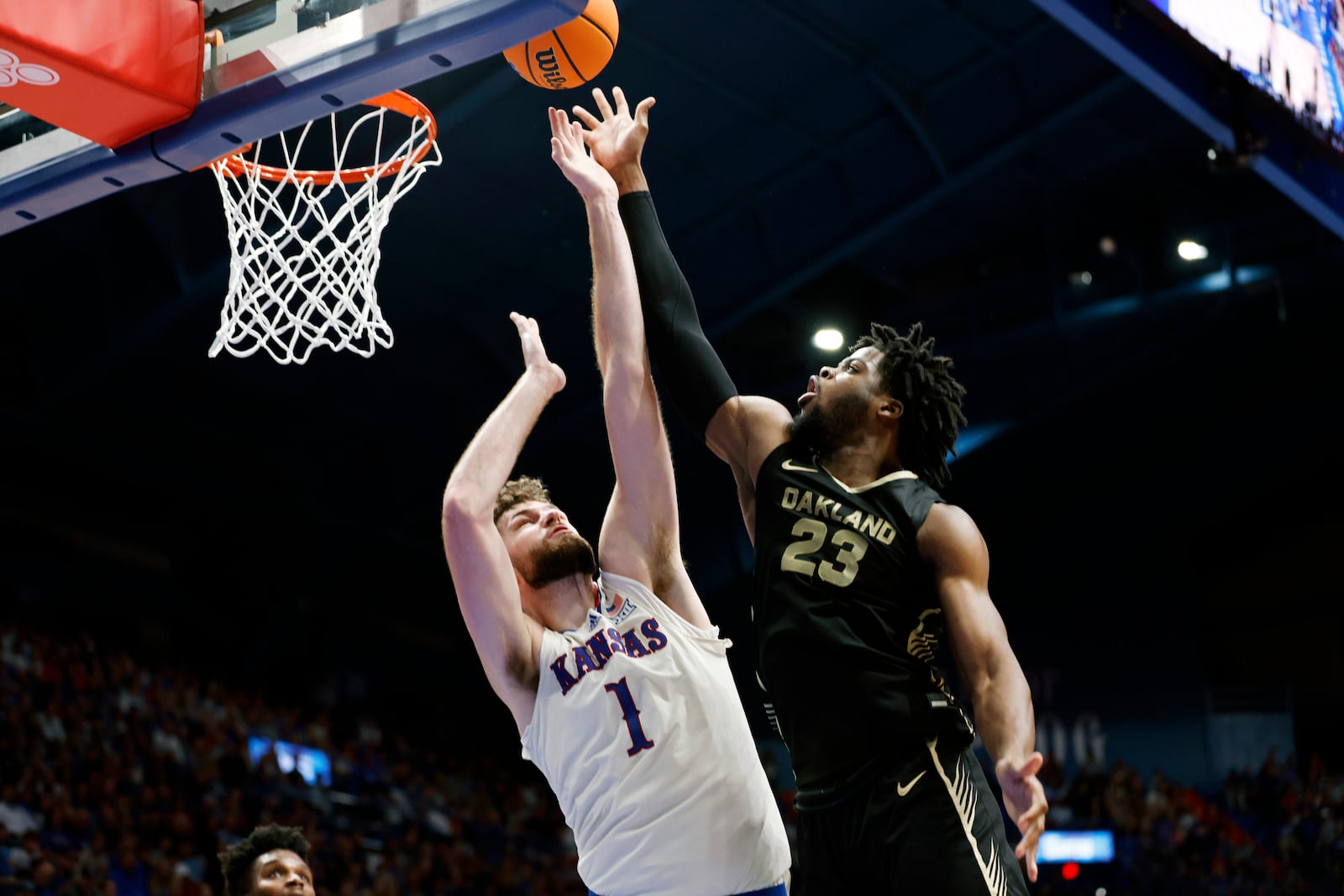 Oakland forward Allen Mukeba (23) attempts to score a Kansas center Hunter Dickinson (1) defends during the second half of an NCAA college basketball game, Saturday, Nov. 16, 2024, in Lawrence, Kan. (AP Photo/Colin E. Braley)