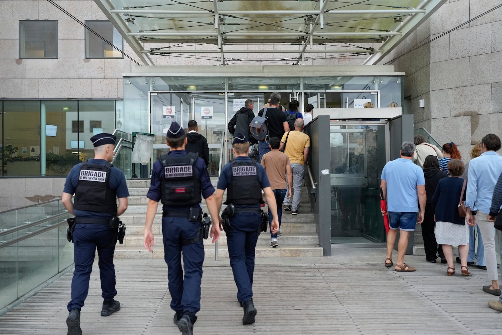 FILE - Police officers walk in the Avignon court house prior to the trial of Dominique Pelicot, in Avignon, southern France, on Sept. 5, 2024. (AP Photo/Lewis Joly, File)