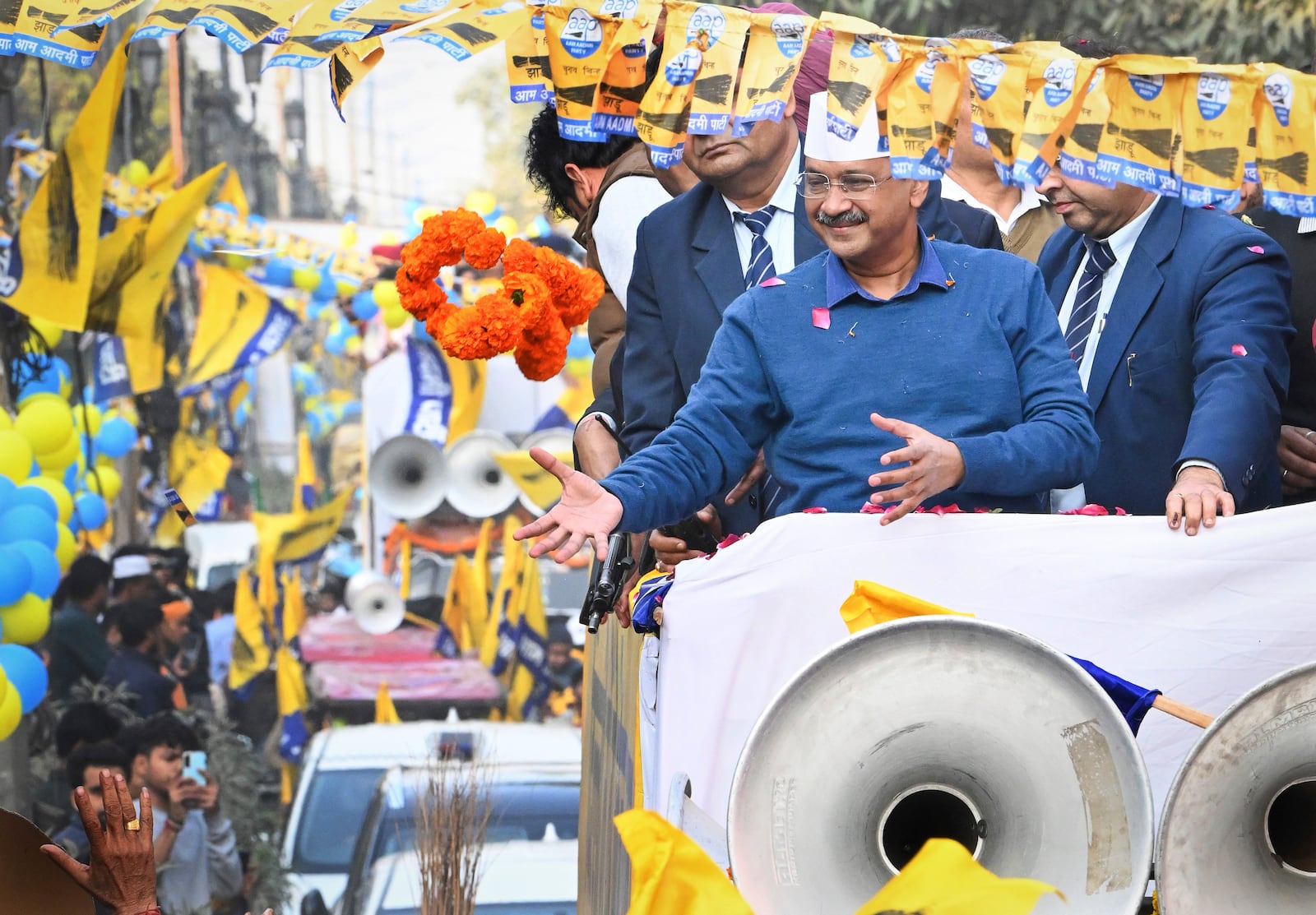 Aam Aadmi Party (AAP) national convener Arvind Kejriwal, catches a garland during a road show while campaigning for Delhi state election in New Delhi, India, Monday, Feb. 3, 2025. (AP Photo)