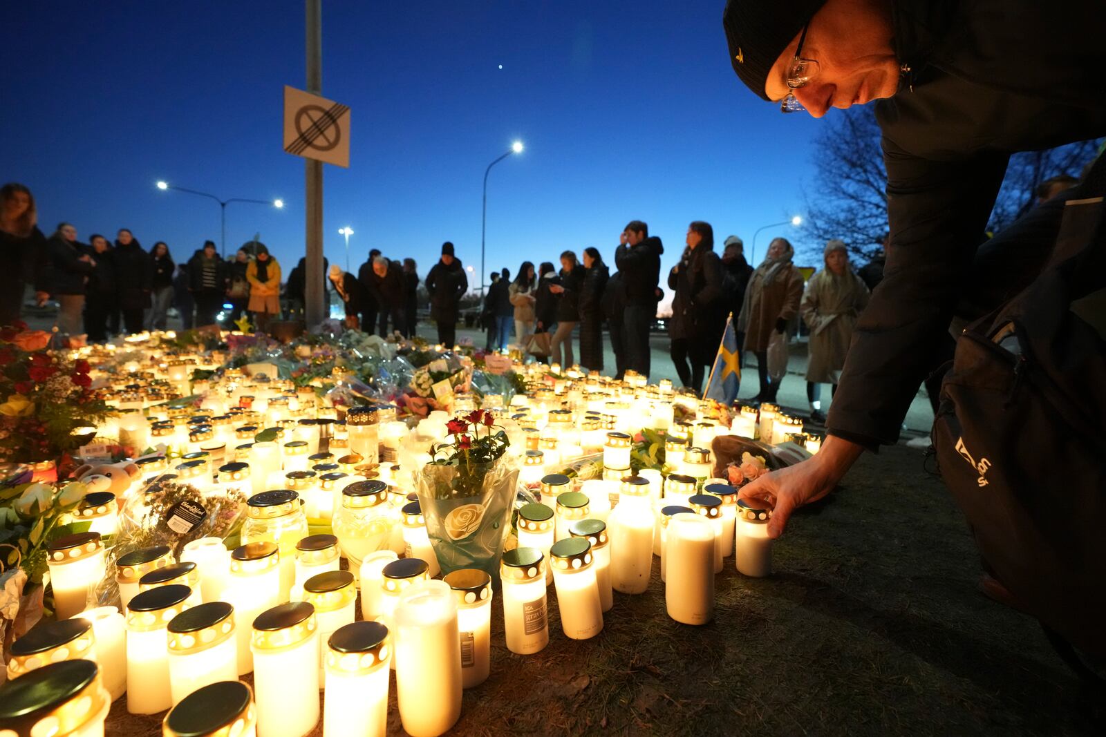 People take part in a vigil near the scene of a shooting at an adult education center on the outskirts of Orebro, Sweden, Thursday, Feb. 6, 2025. (AP Photo/Sergei Grits)