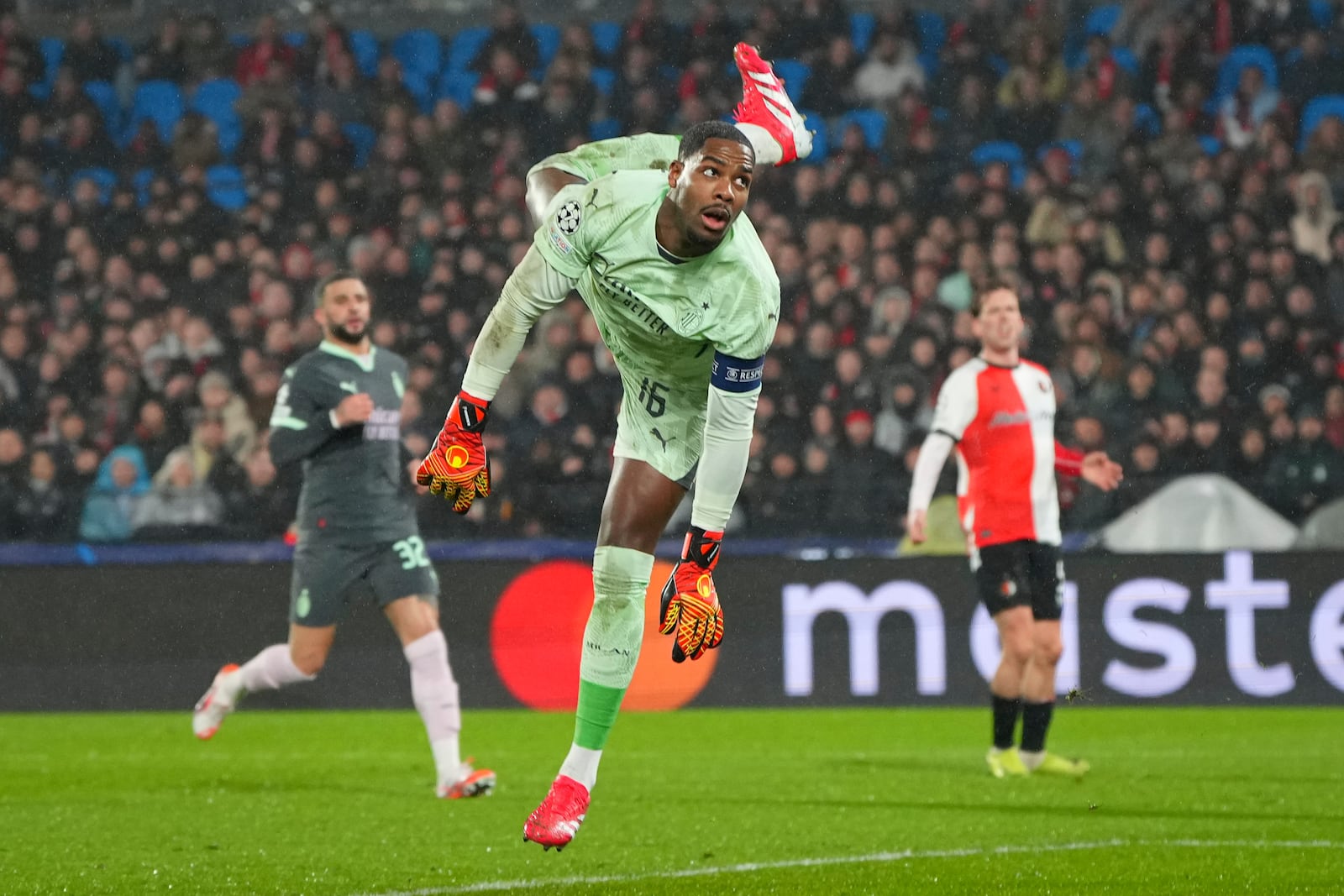 AC Milan's goalkeeper Mike Maignan dives to save a shot during the Champions League playoff first leg soccer match between Feyenoord and AC Milan, at the De Kuip stadium, in Rotterdam, Netherlands, Wednesday, Feb. 12, 2025. (AP Photo/Peter Dejong)