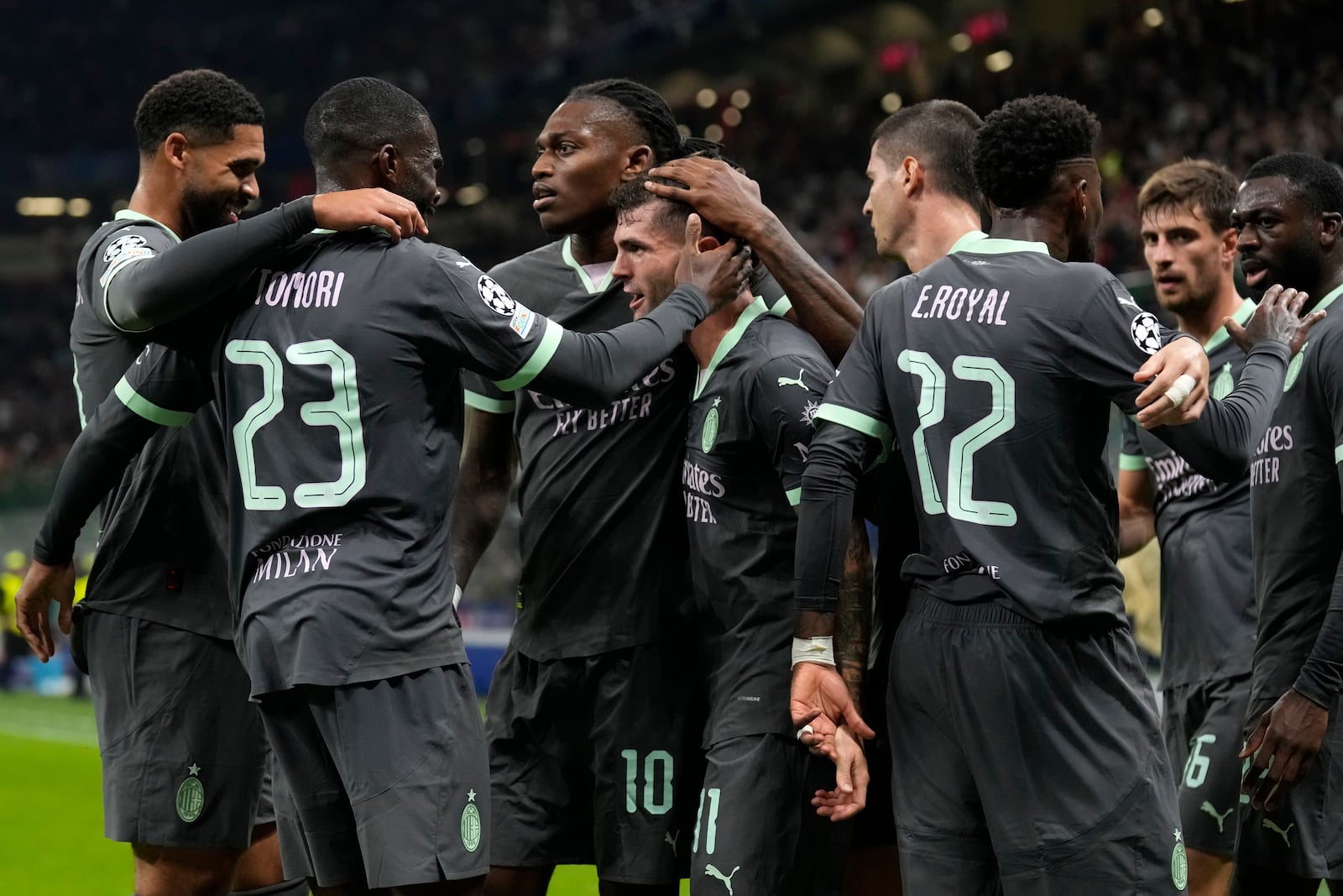 AC Milan's Christian Pulisic, center, celebrates with teammates after scoring his side's first goal during the Champions League opening phase soccer match between AC Milan and Club Brugge at the San Siro stadium in Milan, Italy, Tuesday, Oct. 22, 2024. (AP Photo/Antonio Calani)