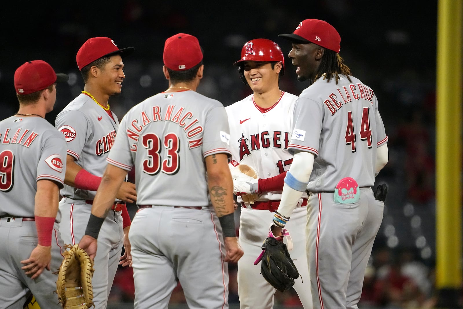 Los Angeles Angels' Shohei Ohtani, second from right, talks with Cincinnati Reds Matt McLain, left, Noelvi Marte, second from left, Christian Encarnacion-Strand, center, and Elly De La Cruz as he stands on second during a pitching change in the fifth inning in the second baseball game of a doubleheader Wednesday, Aug. 23, 2023, in Anaheim, Calif. (AP Photo/Mark J. Terrill)