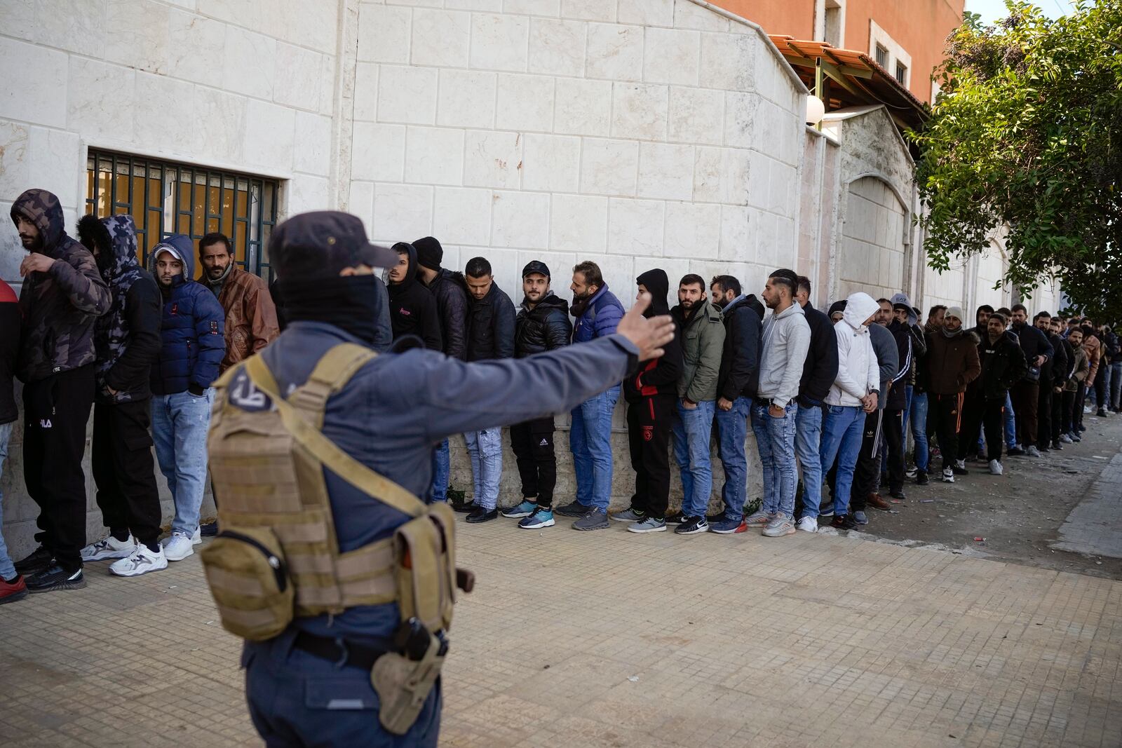 Members from Bashar Assad's Syrian army period line up to register with Syrian rebels as part of a "identification and reconciliation process" at a army compound in Latakia, Syria, Tuesday Dec. 17, 2024.(AP Photo/Leo Correa)