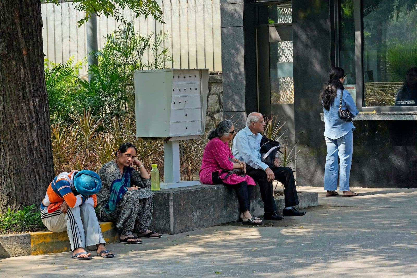 People wait outside the Canadian high commission in New Delhi, India, Tuesday, Oct. 15, 2024 after India and Canada expelled each other’s top diplomats over an ongoing dispute about the killing of a Sikh activist in Canada. (AP Photo/Manish Swarup)