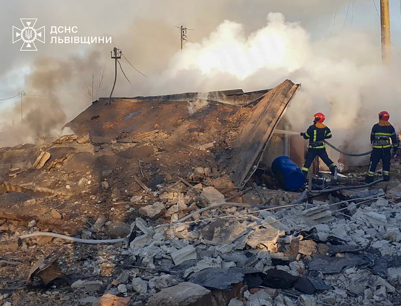 In this photo provided by the Ukrainian Emergency Service, emergency services personnel work to extinguish a fire following a Russian rocket attack in Lviv, Ukraine, Sunday, Nov. 17, 2024. (Ukrainian Emergency Service via AP)