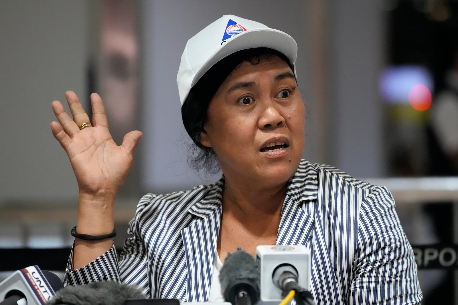 Felicilda Aboc, who has worked for 18 years as a house helper in Lebanon's northern Tripoli city, gestures as she answers questions from reporters upon her arrival at Manila's International Airport, Philippines, Thursday, Oct. 17, 2024. (AP Photo/Aaron Favila)