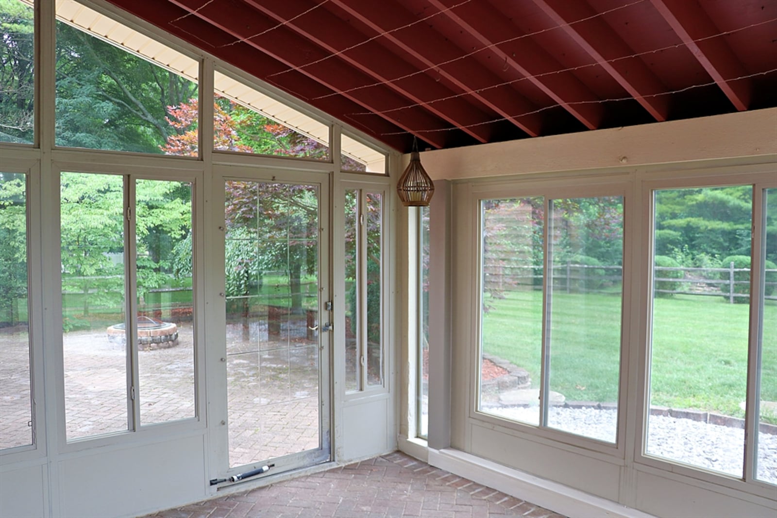 The porch has a vaulted ceiling, windows with screens and a paver-brick floor. Two separate doors open off the enclosed porch out to two separate patios.