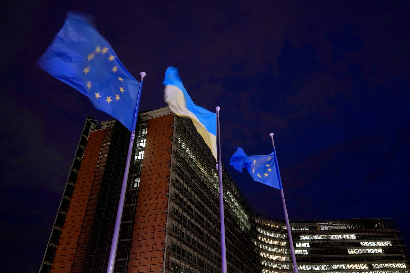 European Union and Ukrainian flags flap in the wind on the day to mark the third anniversary of Russia's full-scale invasion of Ukraine, at EU headquarters in Brussels, Monday, Feb. 24, 2025. (AP Photo/Virginia Mayo)