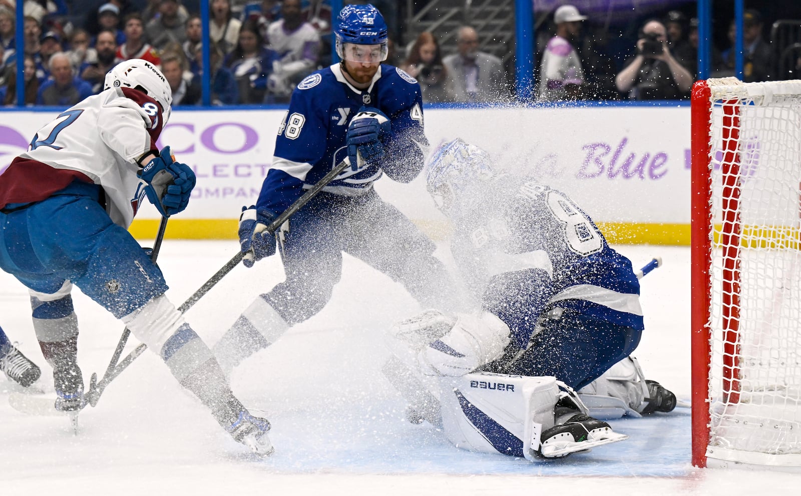 Colorado Avalanche center Ivan Ivan (82) scores against Tampa Bay Lightning defenseman Nick Perbix (48) and goaltender Andrei Vasilevskiy (88) during the first period of an NHL hockey game Monday, Nov. 25, 2024, in Tampa, Fla. (AP Photo/Jason Behnken)