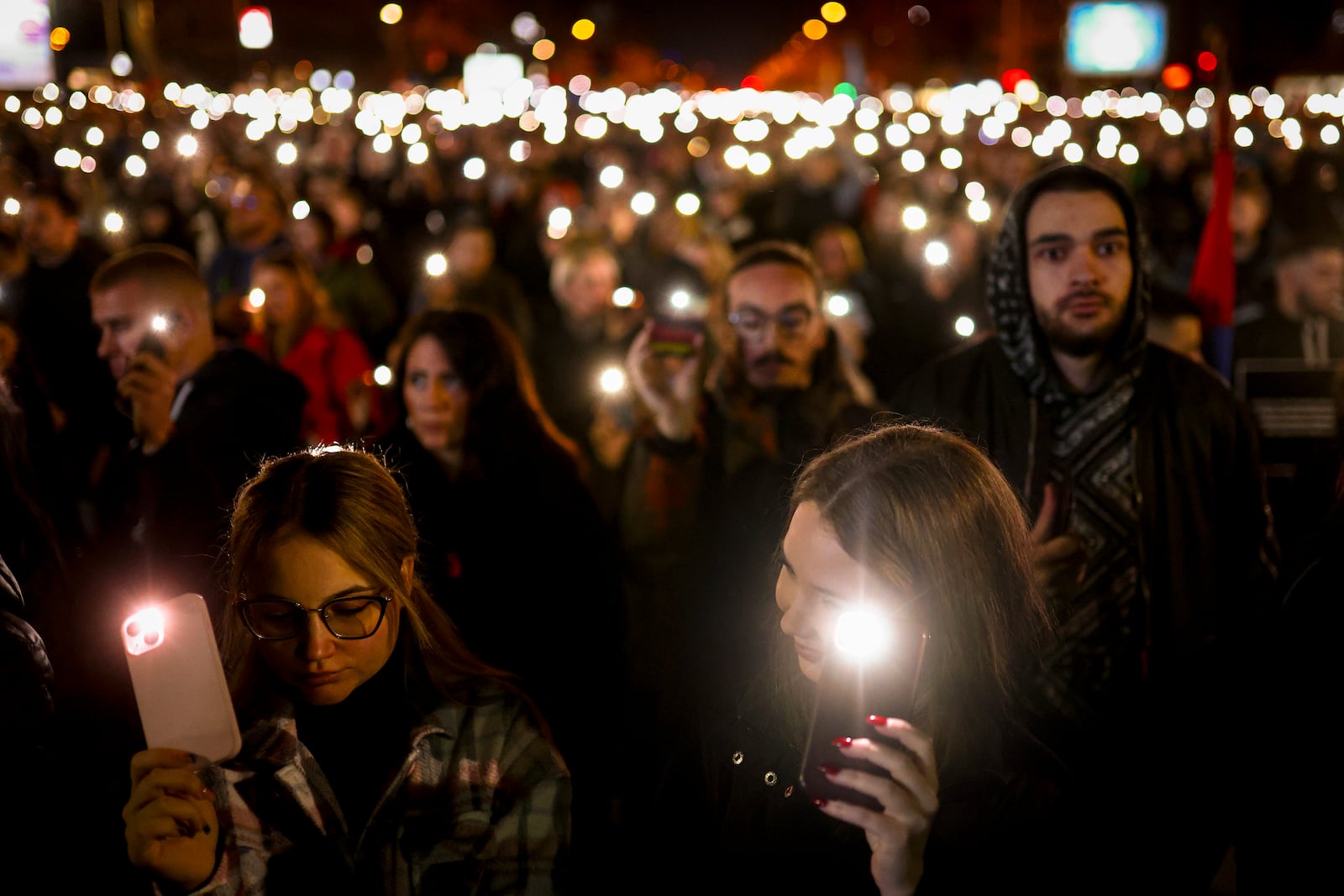 People hold up their mobile phone lights during a protest over the collapse of a concrete canopy that killed 15 people more than two months ago, in Novi Sad, Serbia, Friday, Jan. 31, 2025. (AP Photo/Armin Durgut)