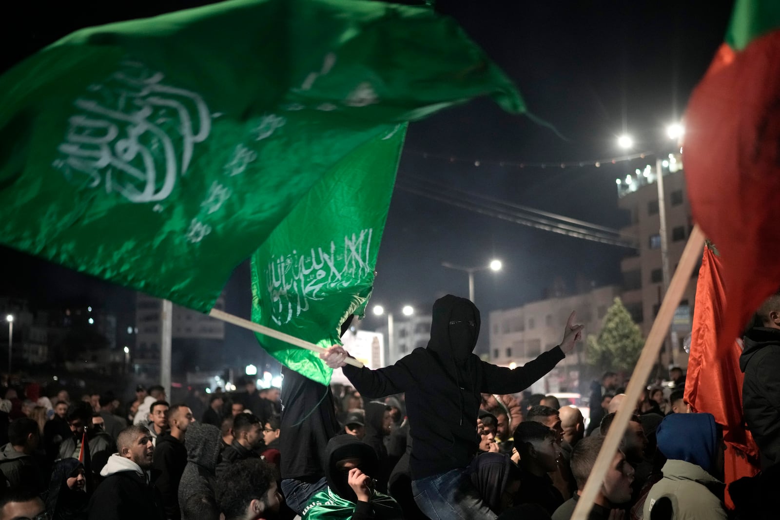 Palestinians celebrate a ceasefire agreement between Hamas and Israel in the West Bank city of Beitunia, on Sunday, Jan. 19, 2025. (AP Photo/Leo Correa)