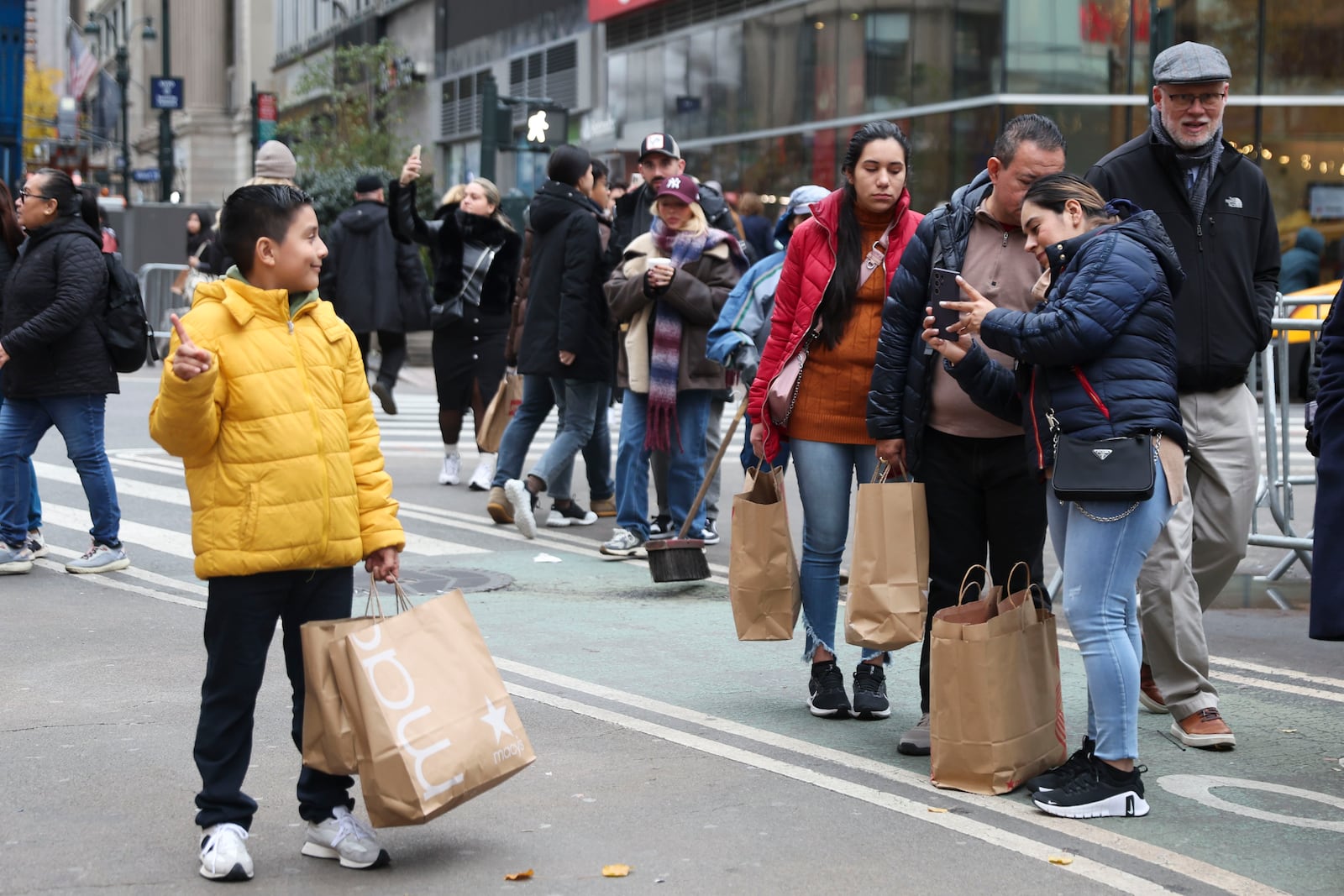 Shoppers take photos outside Macy's Herald Square, Friday, Nov. 29, 2024, in New York. (AP Photo/Heather Khalifa)