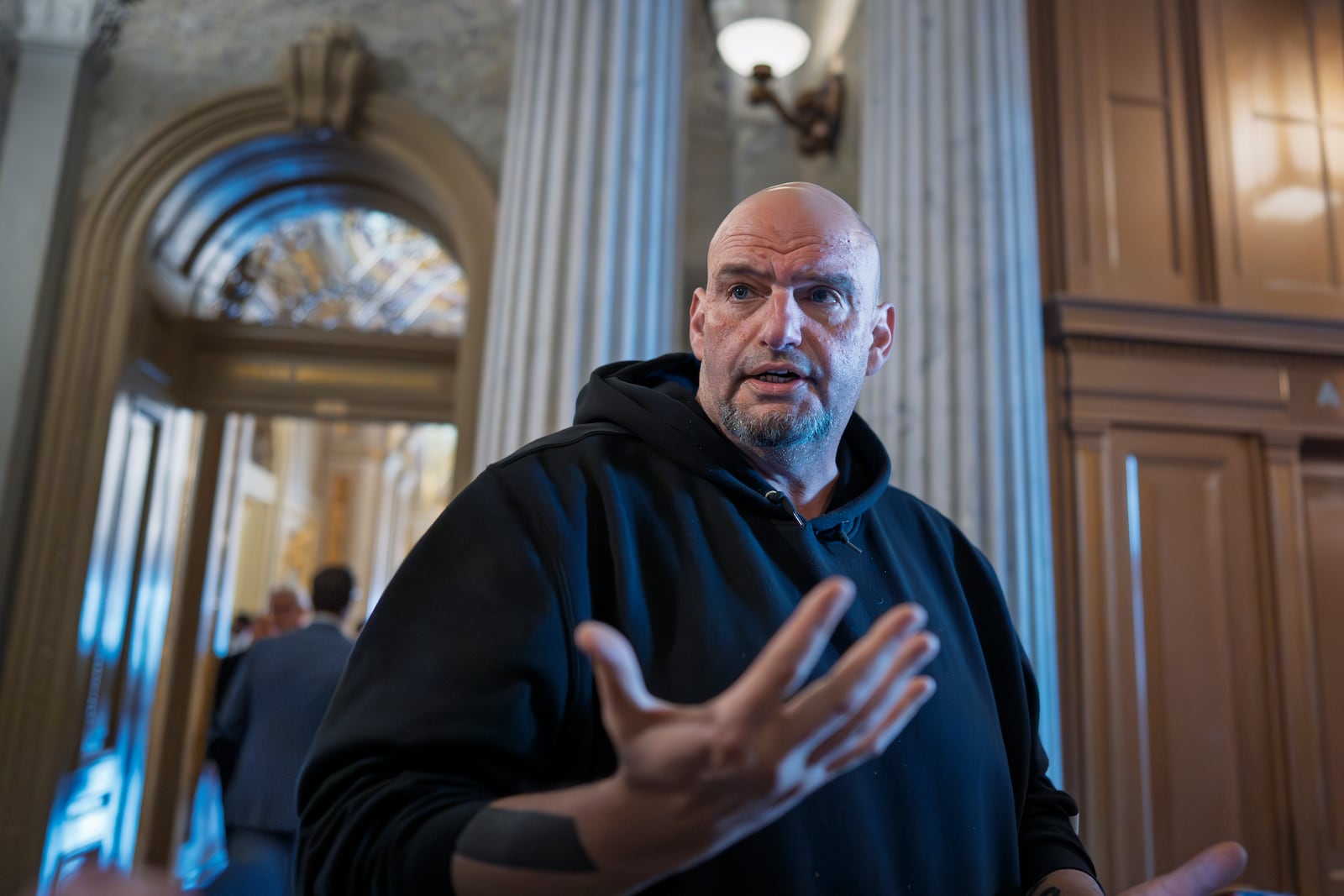 Sen. John Fetterman, D-Pa., talks to reporters outside the chamber during a vote at the Capitol in Washington, Thursday, March 13, 2025. (AP Photo/J. Scott Applewhite)