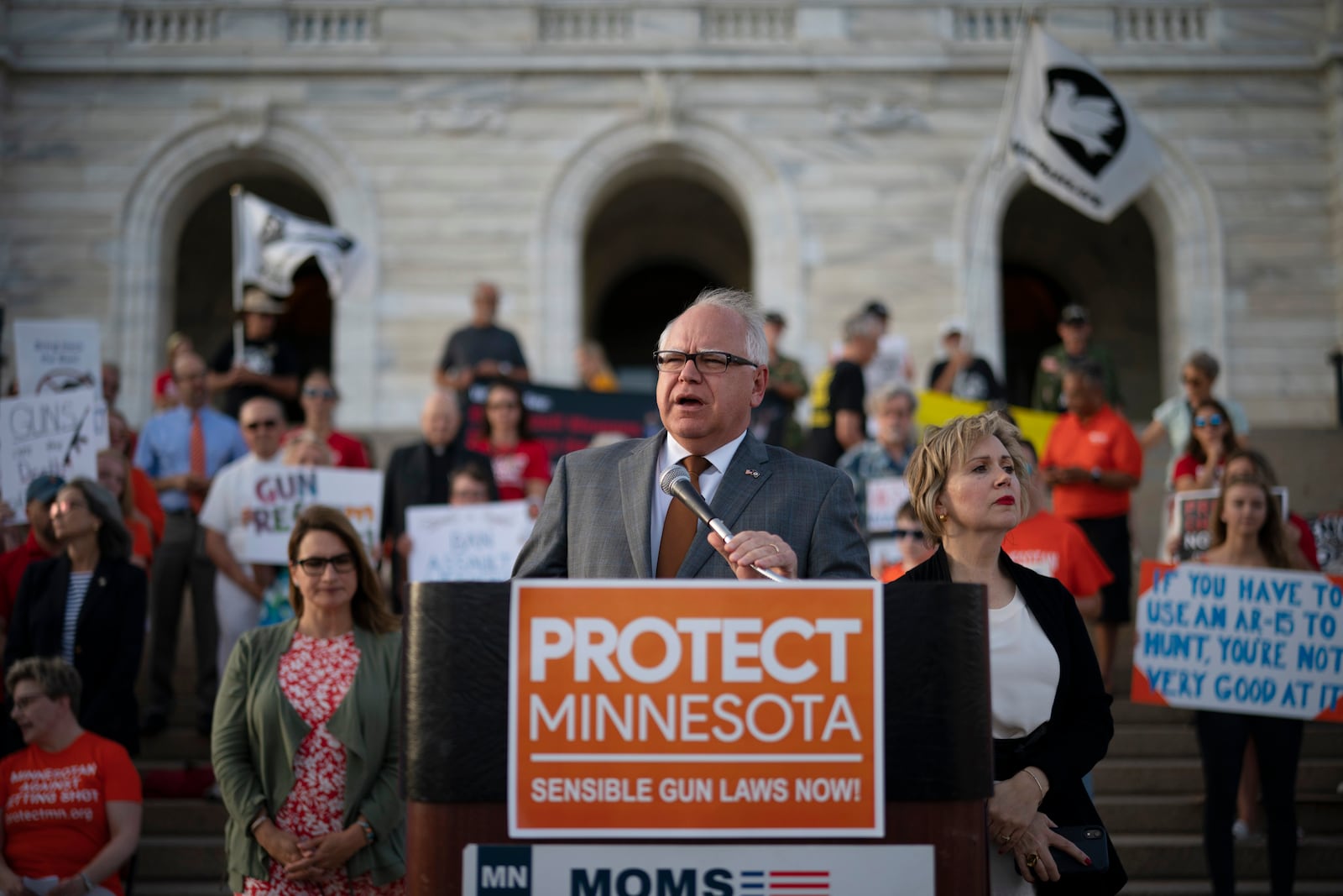 FILE - Gov. Tim Walz speaks before a crowd gathered for a rally on the steps of the state Capitol in St. Paul, Minn., Wednesday evening, Aug. 7, 2019. Lt. Gov. Peggy Flanagan, center left, and his wife Gwen Walz, center right, stand by him. (Jeff Wheeler/Star Tribune via AP, File)