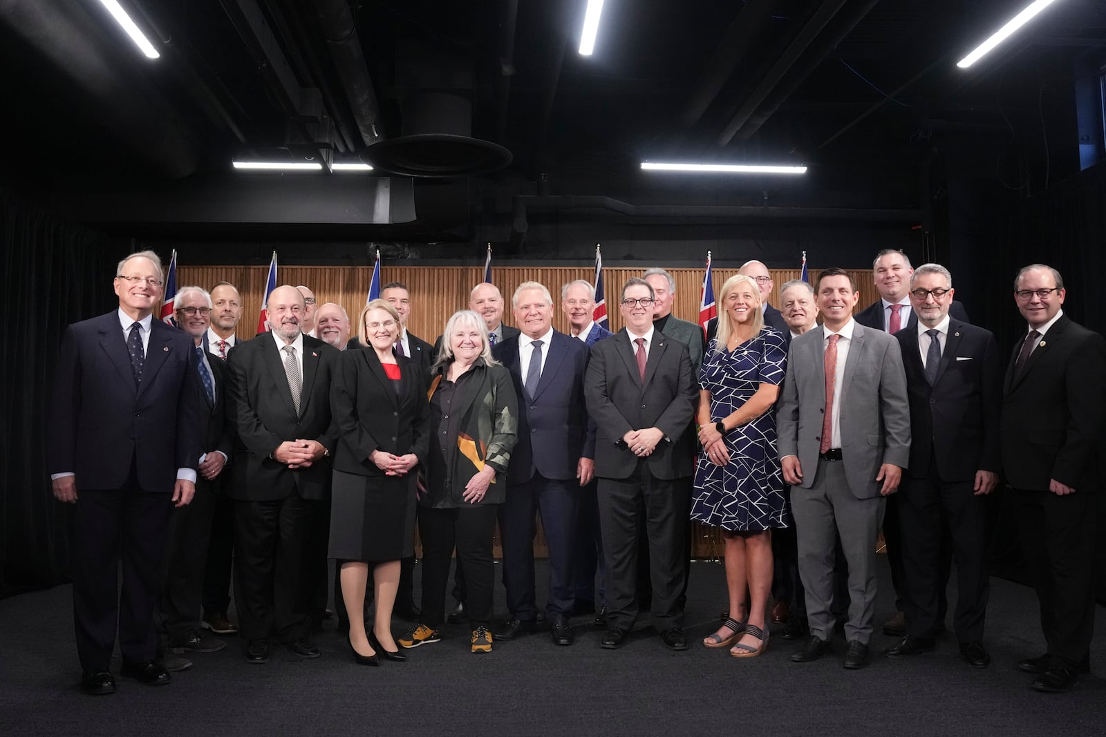 Ontario Premier Doug Ford, center, poses for a photo with mayors from selected municipalities and government ministers during a press conference in the Queen's Park Legislature in Toronto on Thursday Dec. 12, 2024. (Chris Young/The Canadian Press via AP)