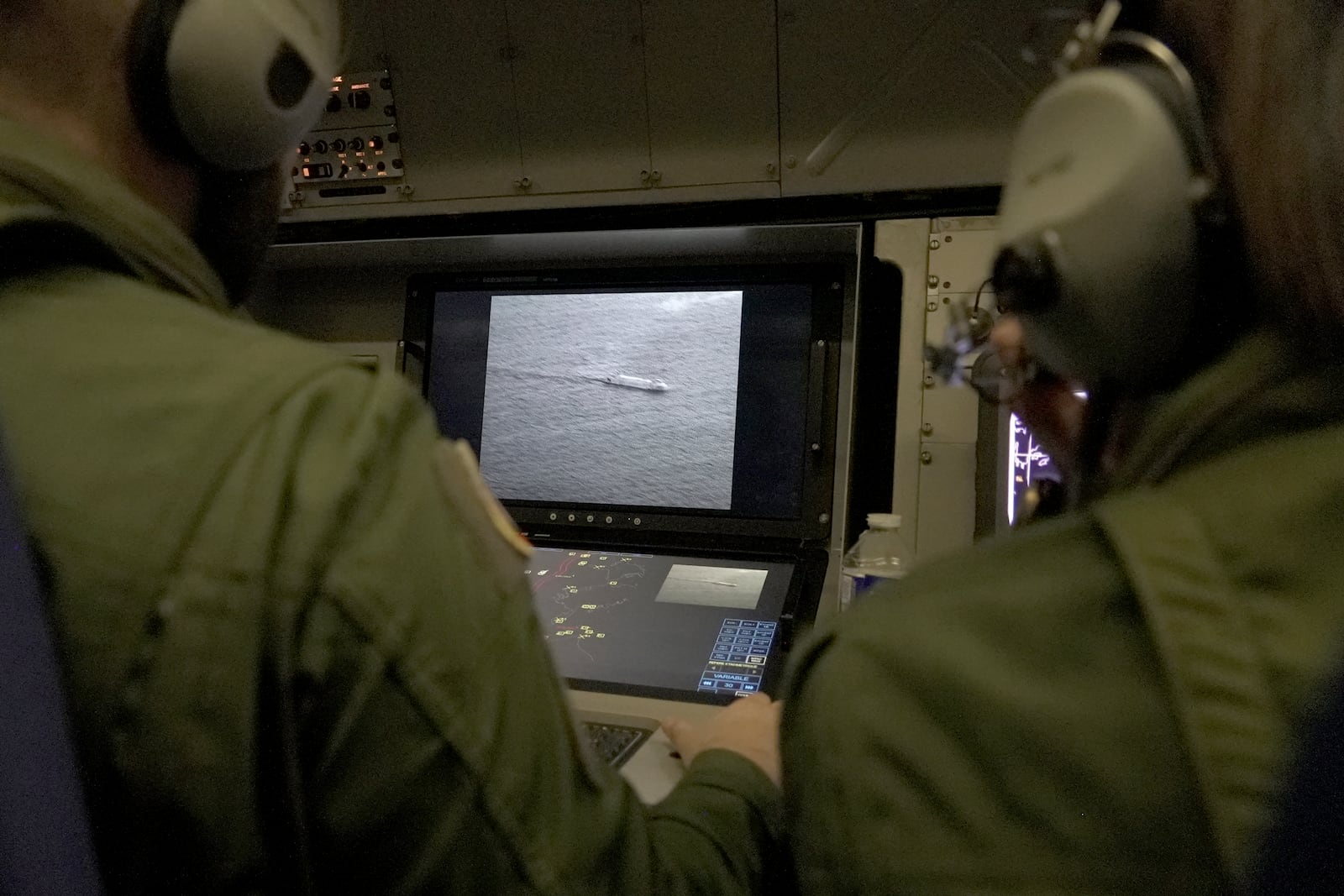 Crew members aboard a French Navy Atlantique 2 surveillance plane patrolling Thursday, Jan. 23, 2025, over the Baltic Sea as part of the NATO military alliance's "Baltic Sentry" mission to protect undersea cables and pipelines from sabotage watch one of the onboard monitors showing images from the aircraft's cameras of a ship navigating on the Baltic. (AP Photo/John Leicester)