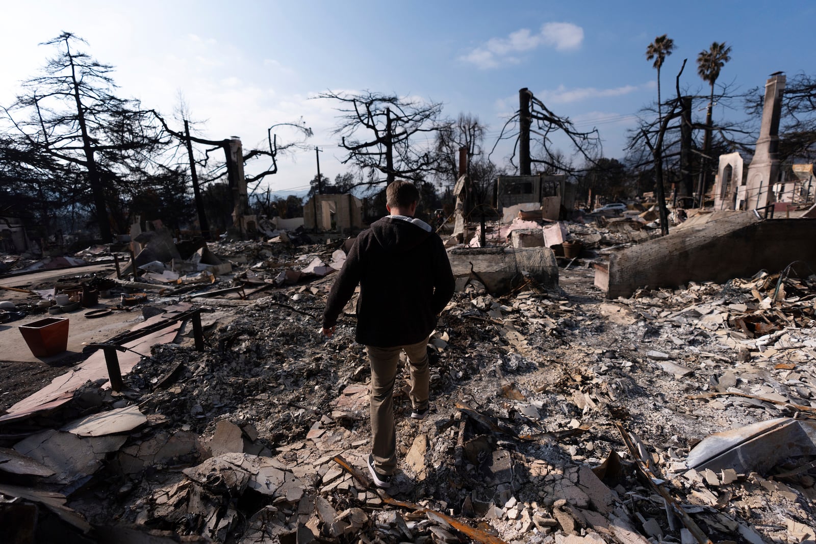 FILE - Chris Wilson walks through the remains of his home, consumed by the Eaton Fire, in Altadena, Calif., Thursday, Jan. 30, 2025. (AP Photo/Jae C. Hong, File )