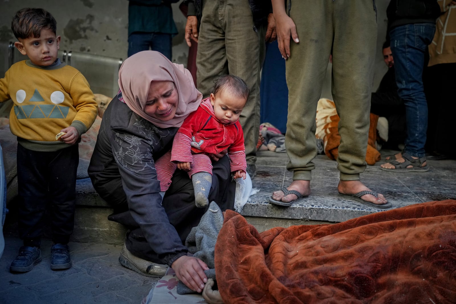 A woman mourns as she identifies a body in the Al-Ahli hospital following overnight Israeli airstrikes across the Gaza Strip, in Gaza City, Tuesday, March 18, 2025. (AP Photo/Jehad Alshrafi)