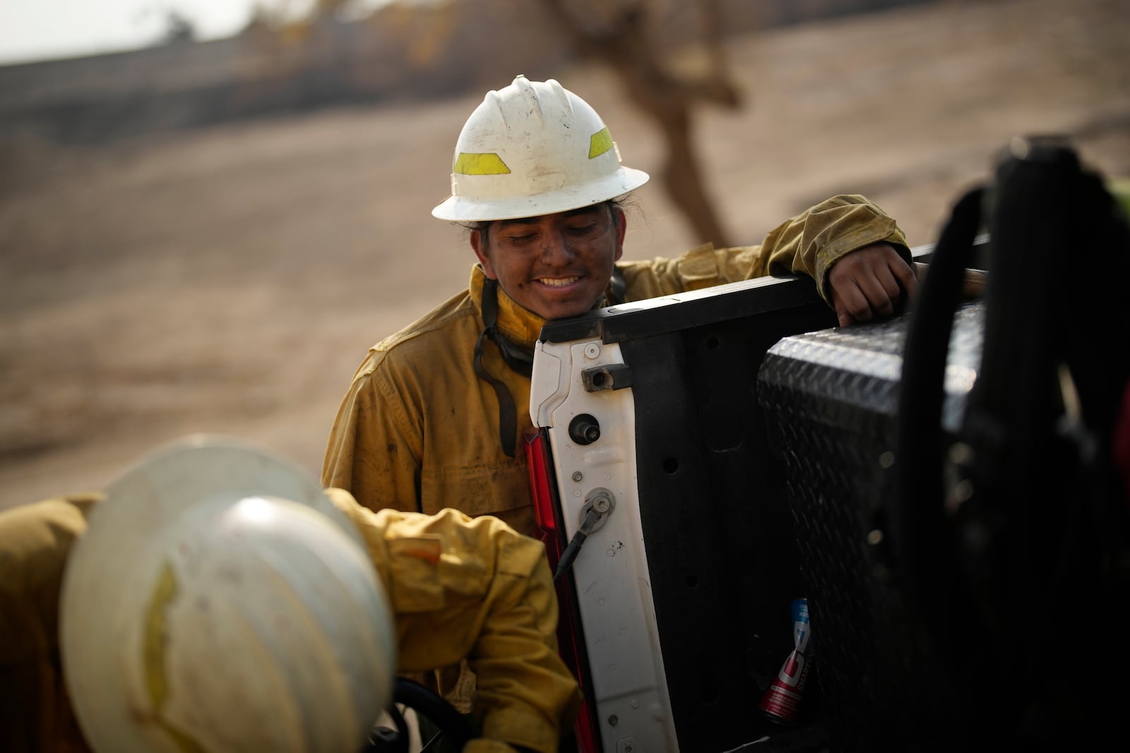 Deago Yanez, a member of the Navajo Scouts firefighter crew, takes a break in between cutting up trees destroyed by the Eaton Fire, Friday, Jan. 17, 2025, in Pasadena, Calif. (AP Photo/John Locher)