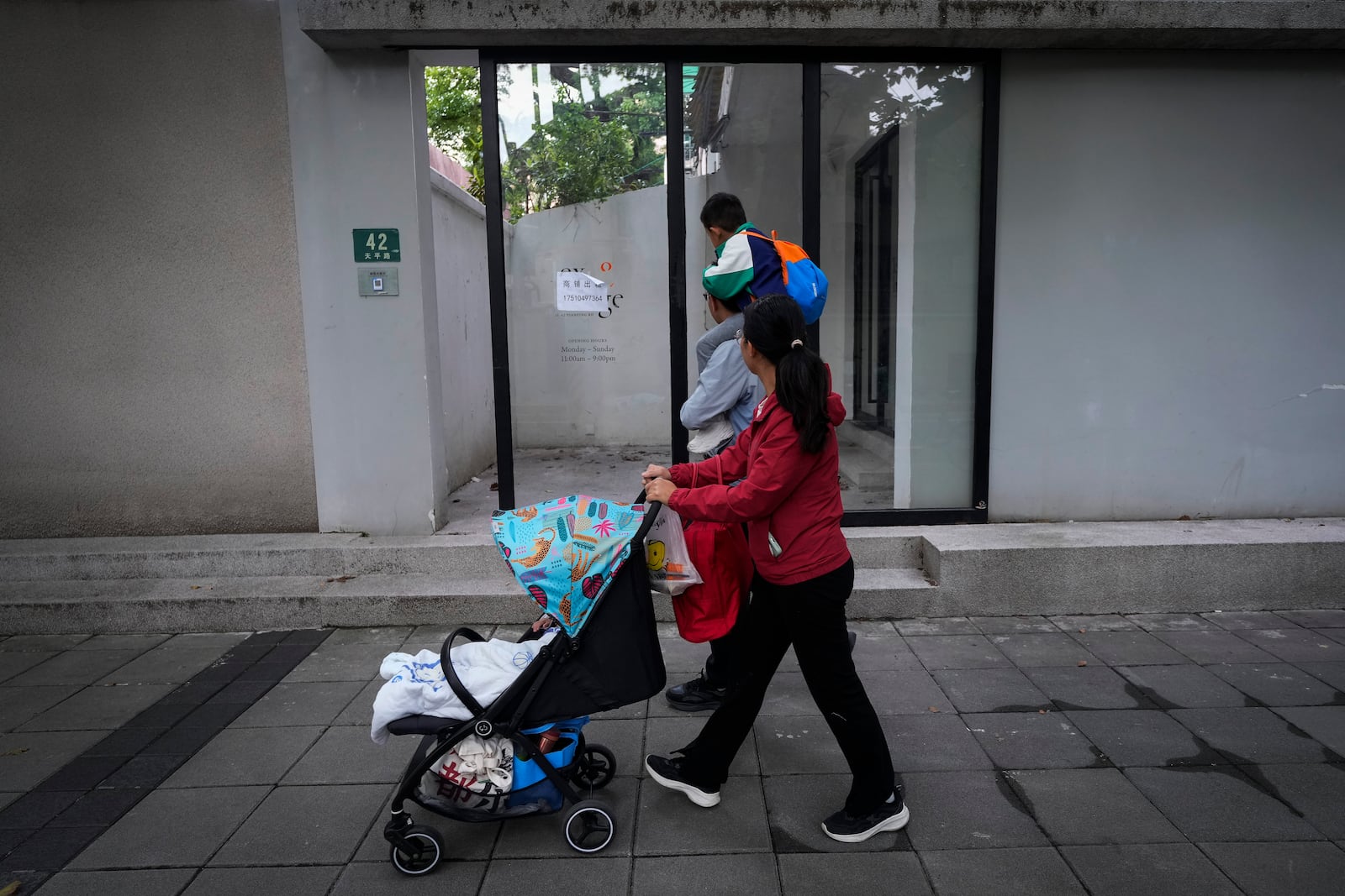 Residents pass by the shuttered Text&Image bookstore in Shanghai, Oct. 9, 2024. (AP Photo/Andy Wong)